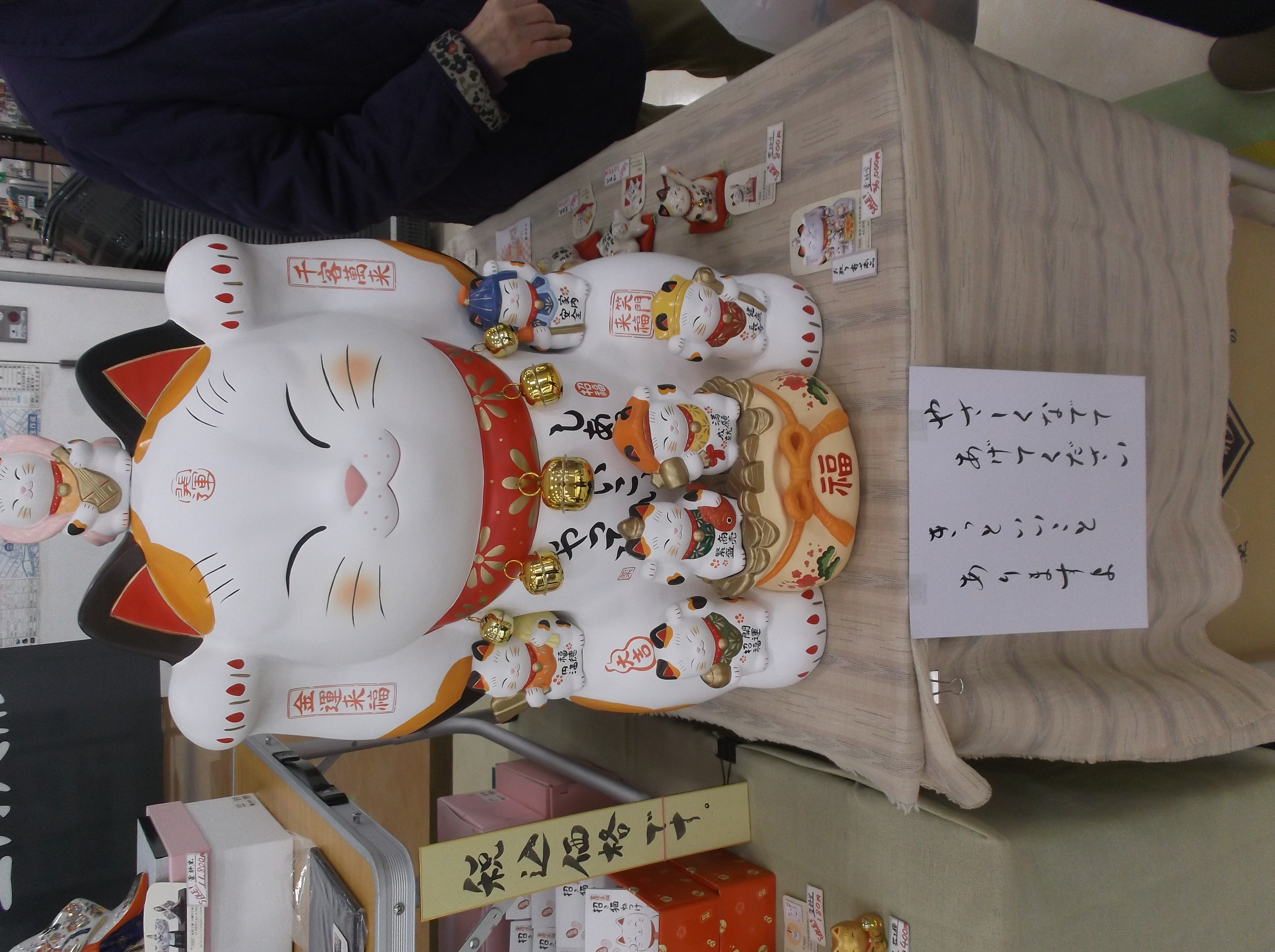 店頭で素焼き人形を販売していました。「招き猫を撫でてください」の貼紙に誘われ、皆で招き猫を撫でました。