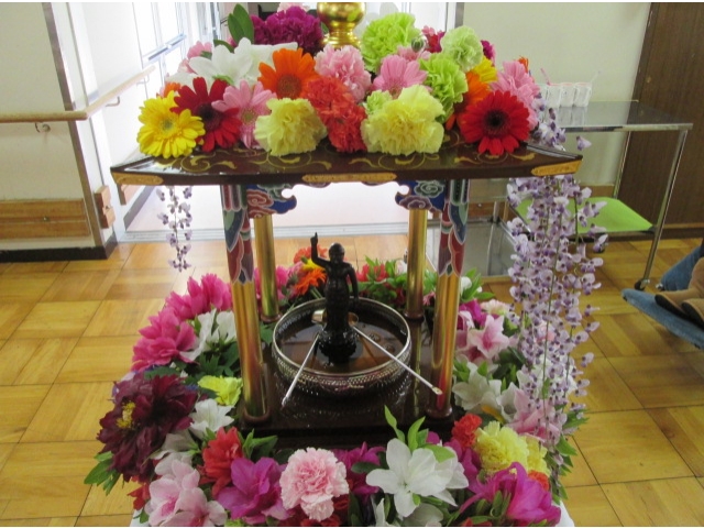 お釈迦様を中心に沢山のお花に囲まれ、甘茶もセットしました。