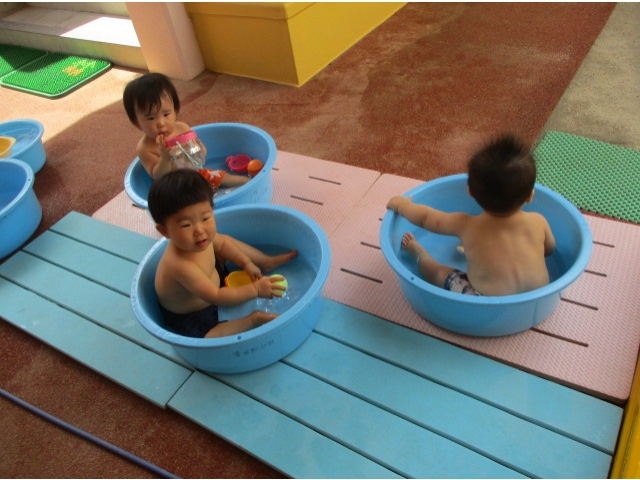 0歳児は、1人ずつのたらいの中で水遊びをします。