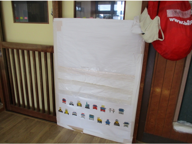 働く車シリーズの絵本のカバーをチョキチョキ✂切ってはりました