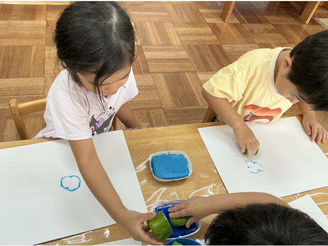 紙と絵の具を用意していざスタンプ！ギューッ、ポンと押していきます♪