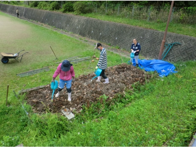 発酵をうながすためじょうろで水をかけます。