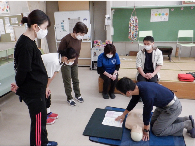 心肺蘇生法の説明を受けています。