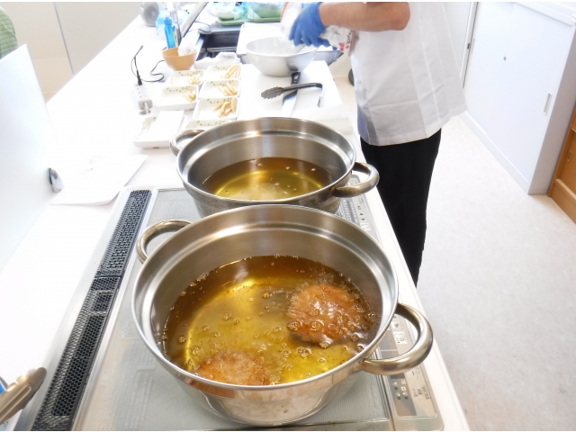 調理師が利用者の皆様の前で揚げています
