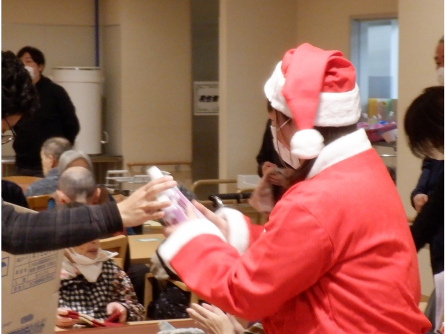 サンタさんがプレゼントを渡しています。