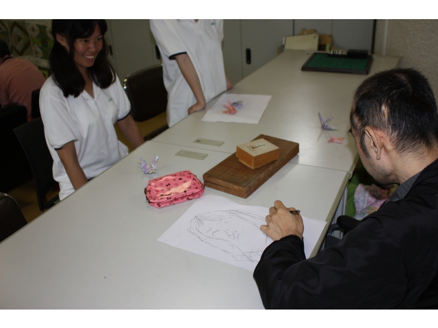 似顔絵を描いてもらいます。真剣です。