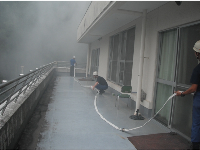 煙の中、ホースをのばして