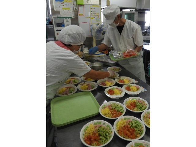 厨房職員は大忙し、みんなで盛り付けます。