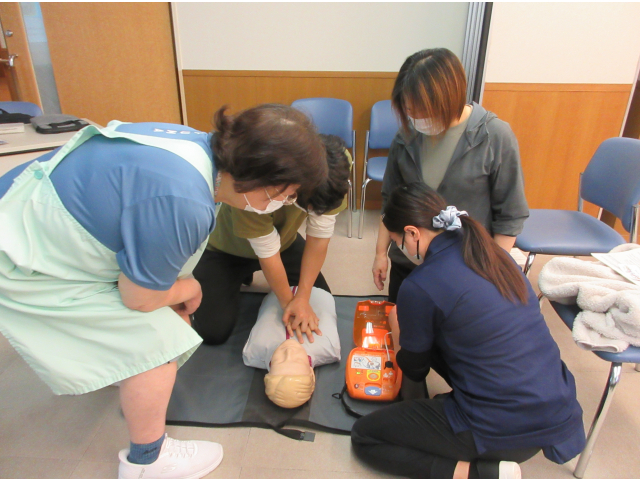 手伝いに来た人達と心臓マッサージしながらAEDの準備