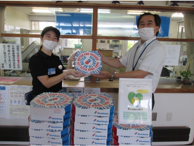 ドミノ・ピザのスタッフの方から苑長へピザの贈呈です。6月9日から11日の3日間で72枚ものピザをいただきました。