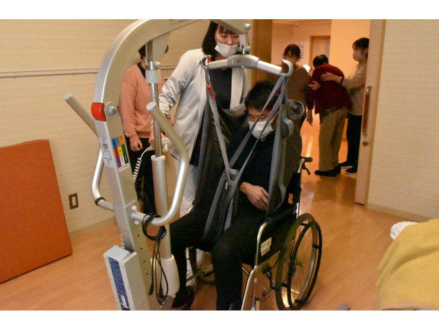 徐々に高さを下げ、車いすに座らせます