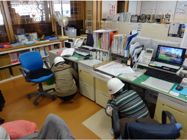 机の下にもぐります