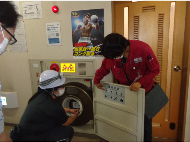 新日本コーポレーションの社員さんによる消火機器取り扱いの説明を聞きます