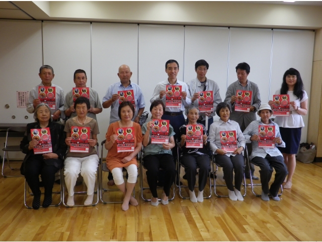 国際交流フェスティバルのチラシを持って記念撮影