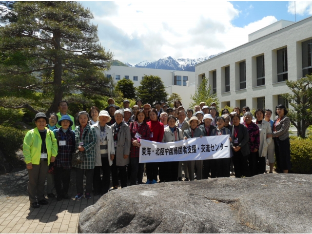 工場と山を背景に、集合写真を撮りました。