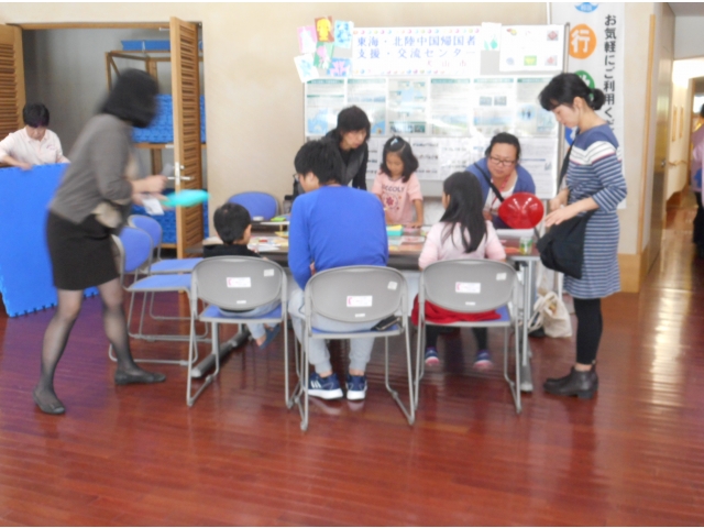 剪紙を体験する小さな子供とそのお父さん・お母さん